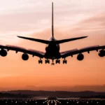 Un avion en train d'atterrir au coucher du soleil