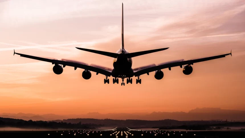 Un avion en train d'atterrir au coucher du soleil
